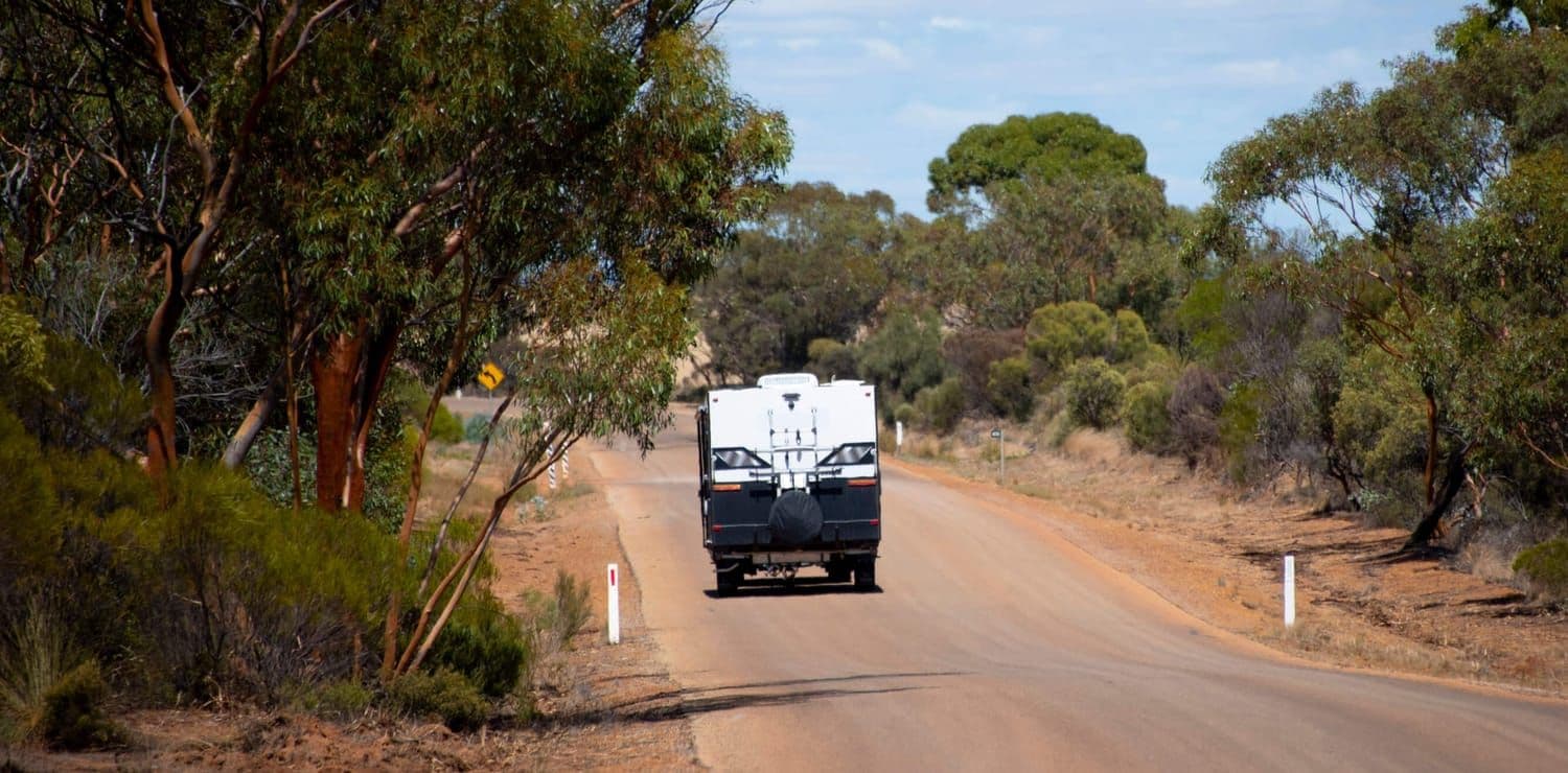 Caravan being towed on a dirt road